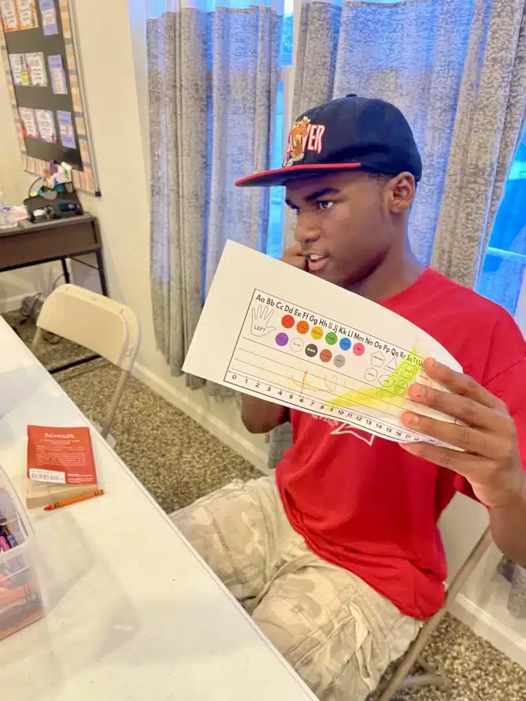 young man in hat showing his work